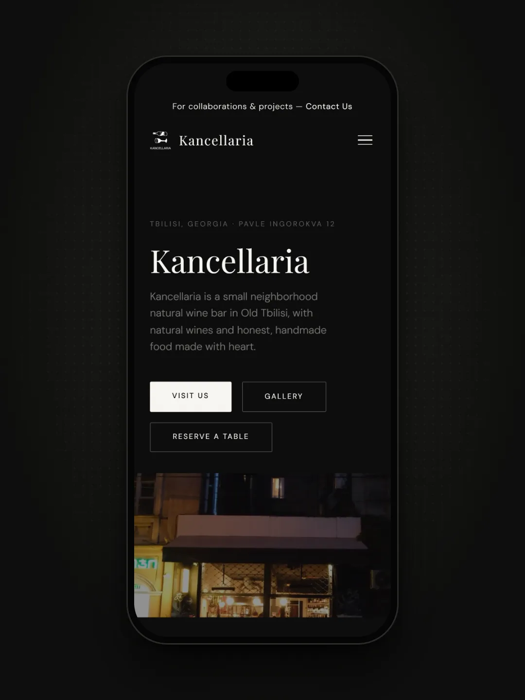 Kancellaria page on a phone, storefront at night
